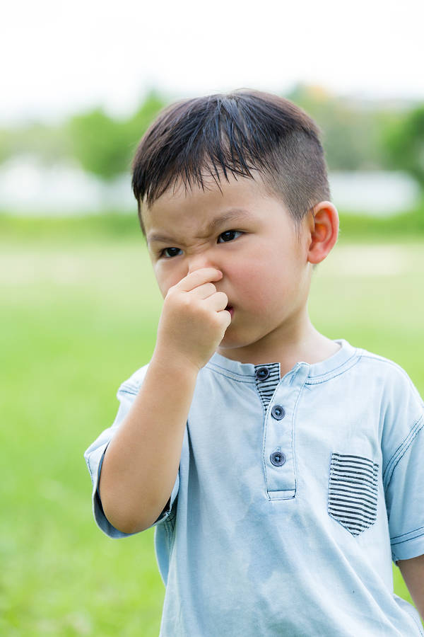 Little kid holding nose - read the Grossology books